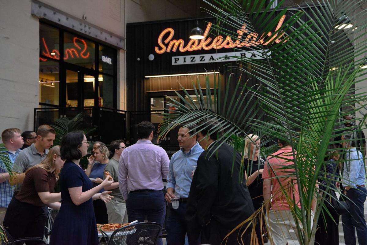 A work party gathered outside the Smokestack neon sign
